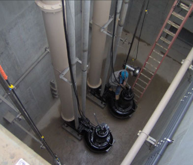 Pump mechanic working in a dry-pit submersible pump station