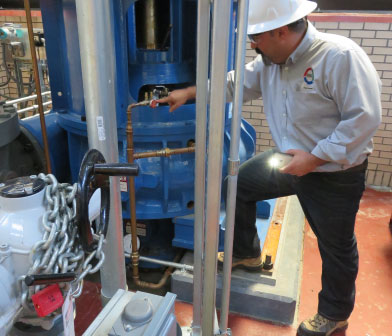 Siewert reliability engineer inspecting seal flush piping plan at City of Buffalo water plant