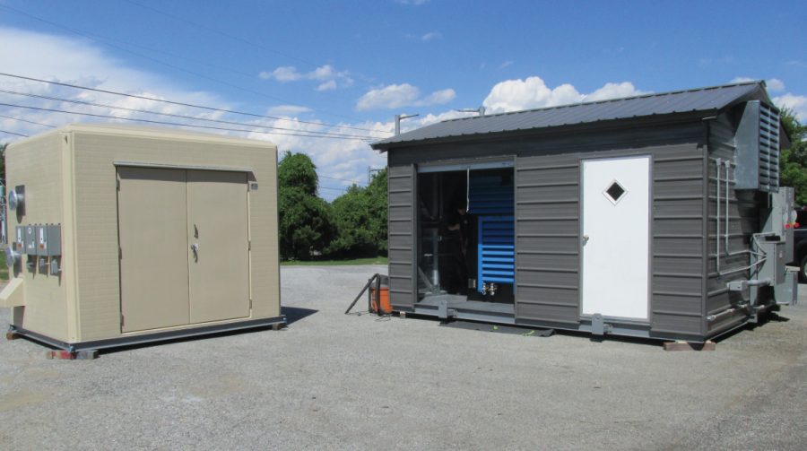 Two custom process equipment packages in fabricated building enclosures outside.